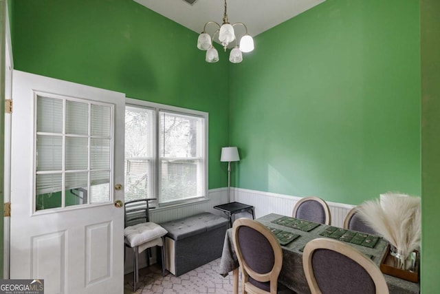 home office featuring a wainscoted wall, lofted ceiling, and a chandelier