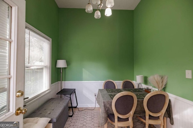 dining room featuring a notable chandelier and a wainscoted wall