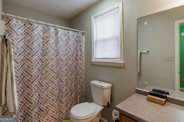 bathroom featuring toilet, vanity, and a textured ceiling