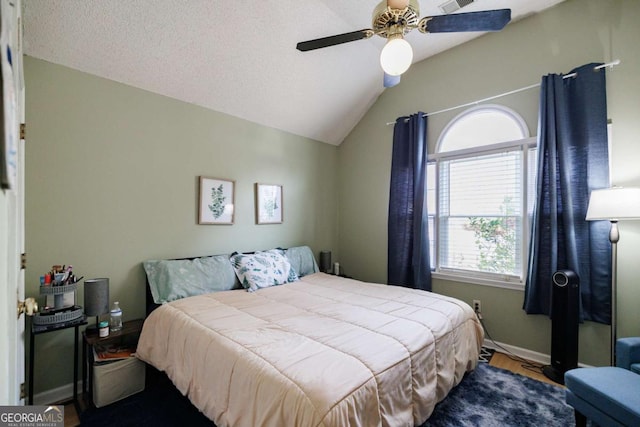 bedroom with a ceiling fan, visible vents, baseboards, lofted ceiling, and a textured ceiling