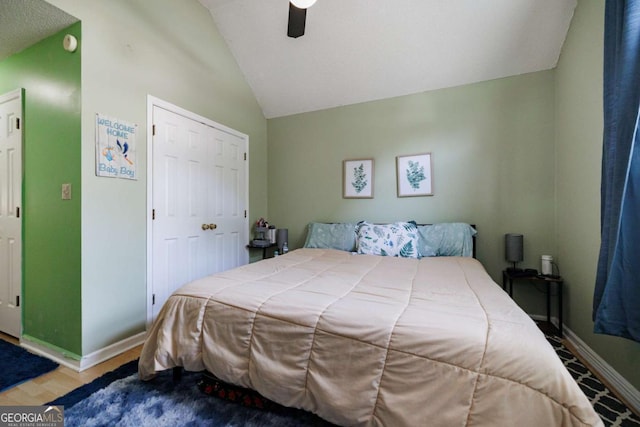 bedroom with a closet, baseboards, a ceiling fan, and vaulted ceiling