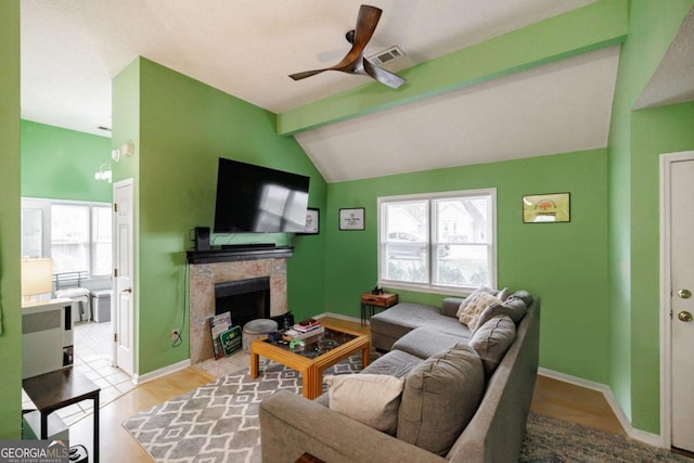 living area with a wealth of natural light, visible vents, a fireplace, and vaulted ceiling with beams