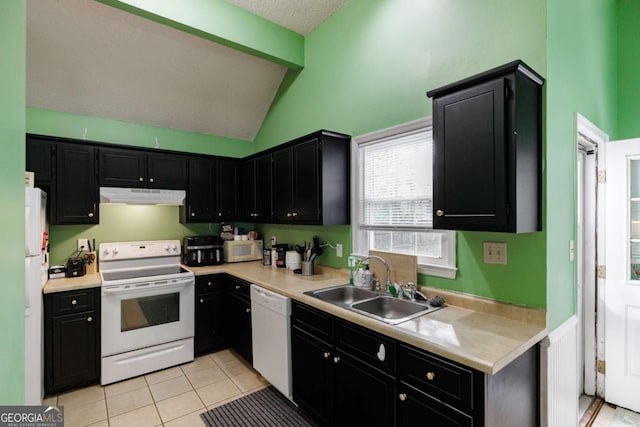 kitchen with a sink, under cabinet range hood, light countertops, white appliances, and dark cabinets