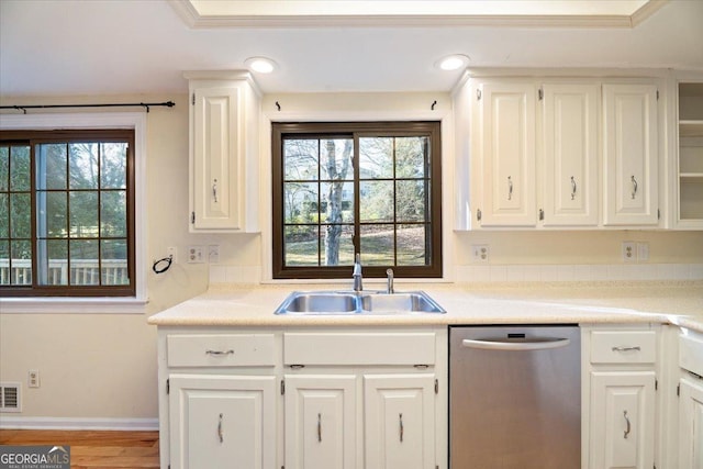 kitchen featuring a sink, dishwasher, white cabinets, and a healthy amount of sunlight