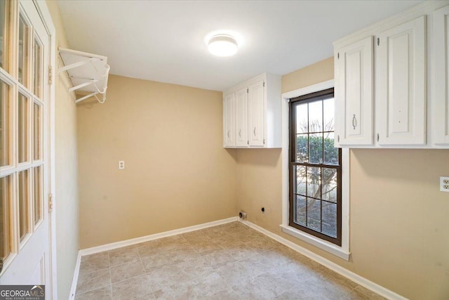 laundry room with cabinet space, baseboards, and hookup for an electric dryer