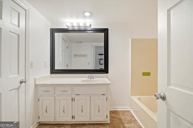 full bath featuring vanity, tile patterned floors, baseboards, and a bathing tub