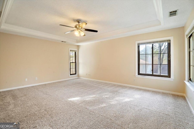 unfurnished room featuring a textured ceiling, a raised ceiling, a ceiling fan, and ornamental molding