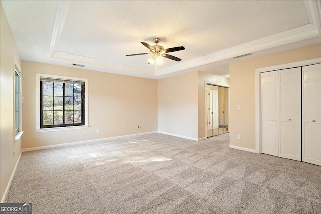 unfurnished bedroom featuring visible vents, a textured ceiling, and a raised ceiling