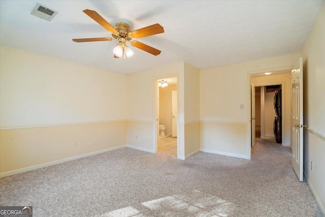 unfurnished room featuring visible vents, baseboards, light colored carpet, and a ceiling fan