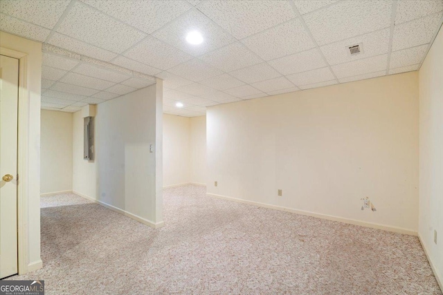 interior space featuring visible vents, baseboards, a paneled ceiling, and carpet