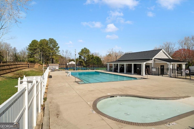 pool with a patio area and fence