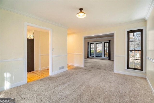 unfurnished room with visible vents, baseboards, carpet, and ornamental molding