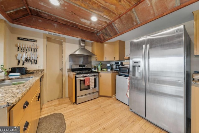 kitchen with a sink, light wood-style floors, appliances with stainless steel finishes, wooden ceiling, and wall chimney range hood