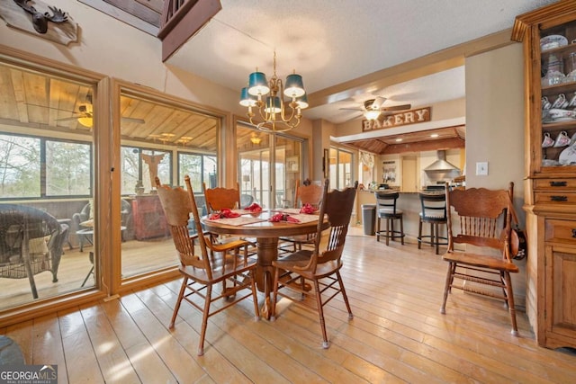 dining room with light wood-type flooring, french doors, and ceiling fan with notable chandelier