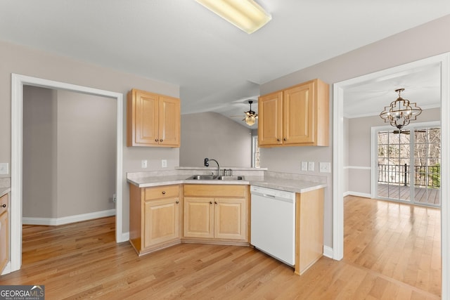 kitchen featuring dishwasher, light countertops, a sink, and light brown cabinetry