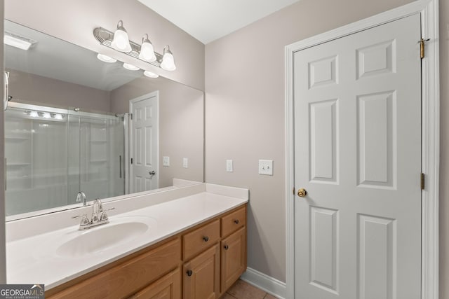 bathroom featuring tile patterned floors, baseboards, vanity, and a shower stall