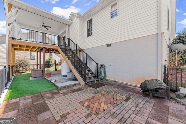 view of patio / terrace featuring ceiling fan, stairs, and fence