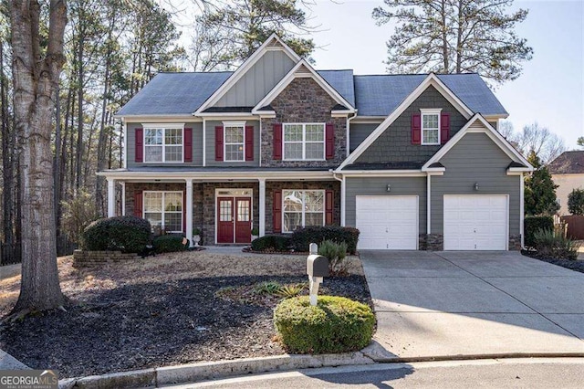 view of front of property with a porch, an attached garage, concrete driveway, stone siding, and board and batten siding