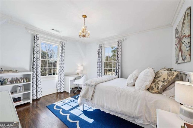 bedroom with crown molding, a notable chandelier, wood finished floors, and visible vents