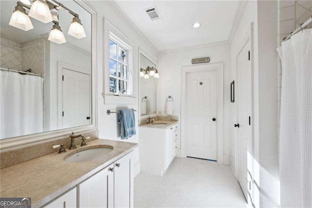 full bath with visible vents, a shower with curtain, two vanities, a sink, and crown molding