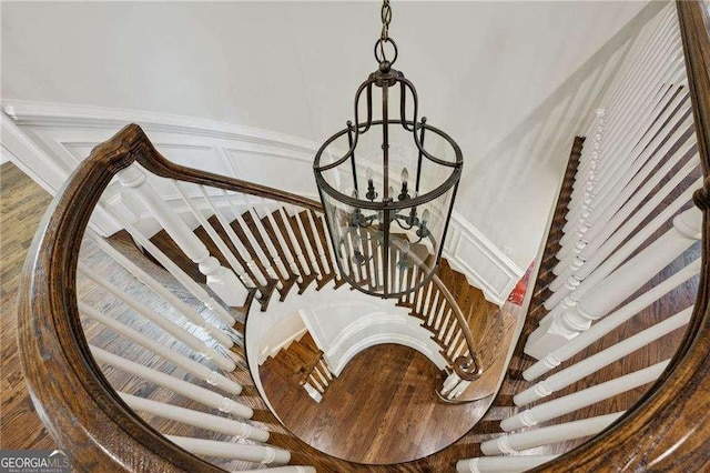 stairway featuring a decorative wall and wainscoting