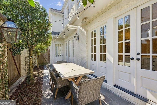 view of patio / terrace with outdoor dining space, french doors, and fence