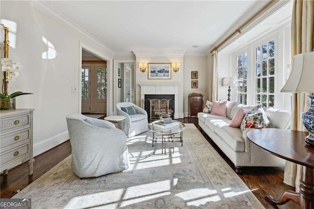 living area featuring a fireplace, crown molding, baseboards, and wood finished floors