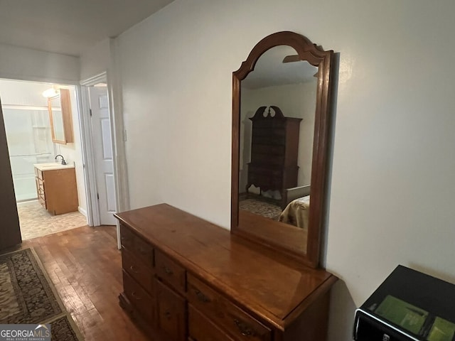 hall with wood finished floors and a sink