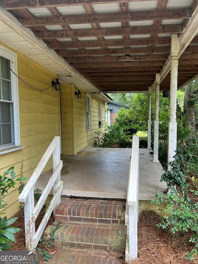 view of patio / terrace featuring a porch, cooling unit, and a carport