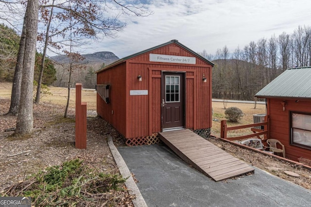 view of outbuilding featuring a mountain view, an outbuilding, and central AC