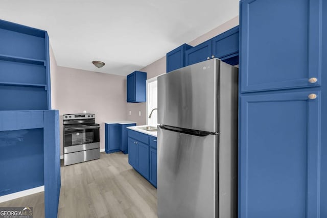 kitchen with open shelves, a sink, light wood-style floors, appliances with stainless steel finishes, and blue cabinets