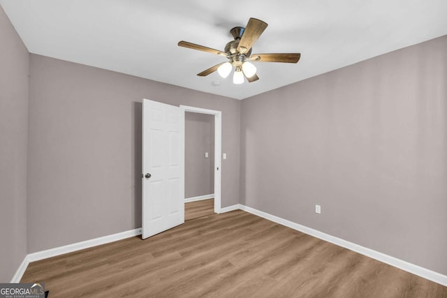 unfurnished bedroom featuring ceiling fan, baseboards, and light wood-style flooring