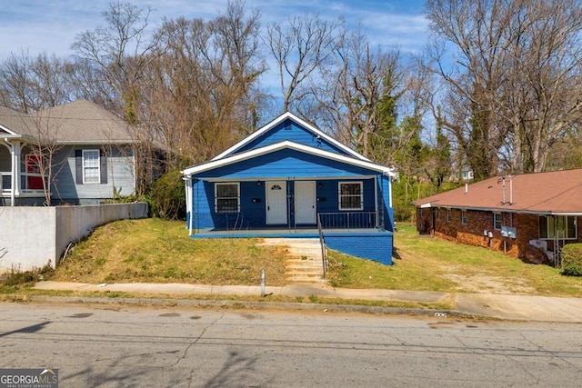 bungalow-style home featuring a porch, french doors, and a front yard