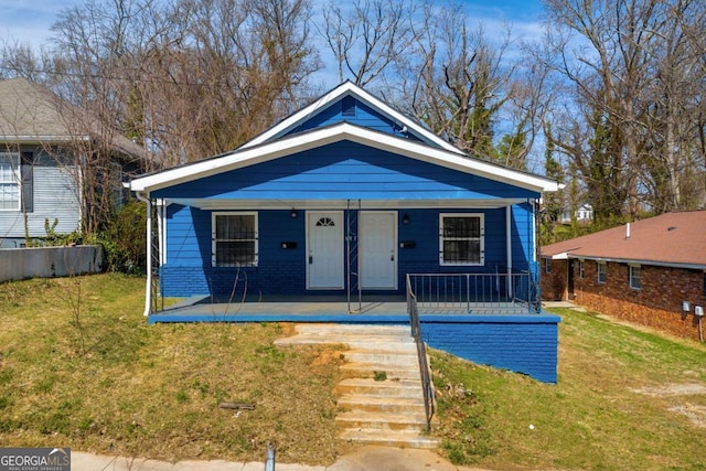 bungalow-style house with brick siding, a porch, and a front yard