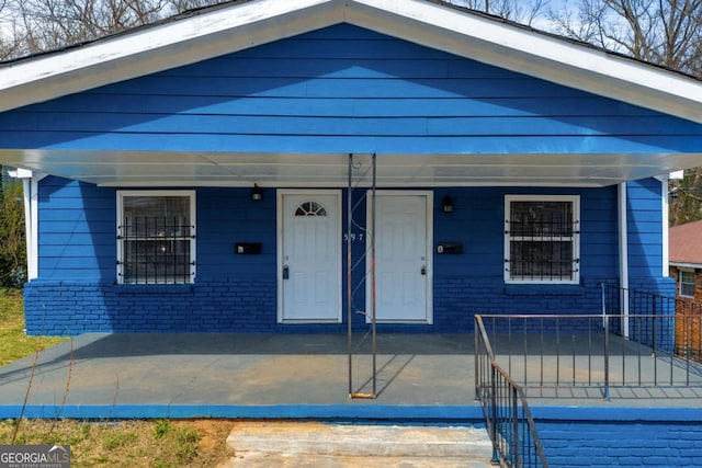 view of front of house with brick siding and covered porch