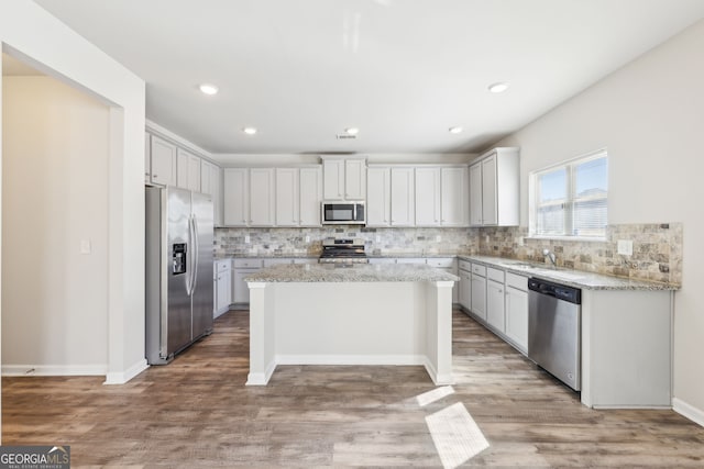 7783 Hansel Ln, Lithonia, GA 30058 - kitchen with stainless steel appliances, a center island, tasteful backsplash, light wood-style flooring, and recessed lighting