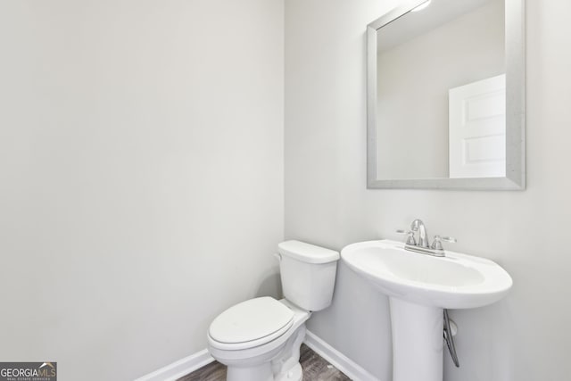 7783 Hansel Ln, Lithonia, GA 30058 - half bathroom featuring wood finished floors, toilet, and baseboards