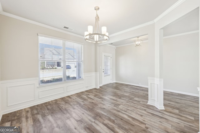 7783 Hansel Ln, Lithonia, GA 30058 - unfurnished dining area with a chandelier, wood finished floors, wainscoting, and ornamental molding
