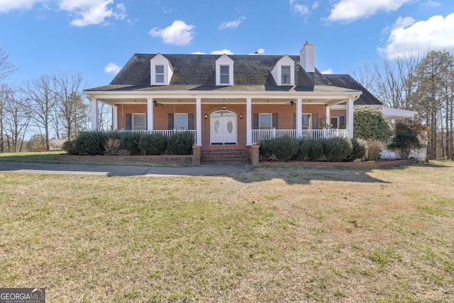 view of front facade with brick siding, covered porch, and a front lawn