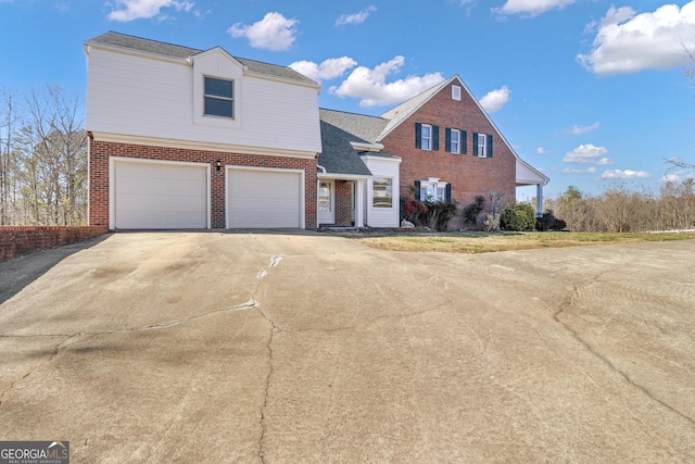 view of front facade with brick siding, an attached garage, concrete driveway, and roof with shingles