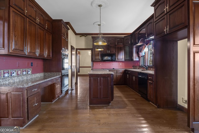 kitchen featuring a kitchen island, dark wood-type flooring, black appliances, and built in desk