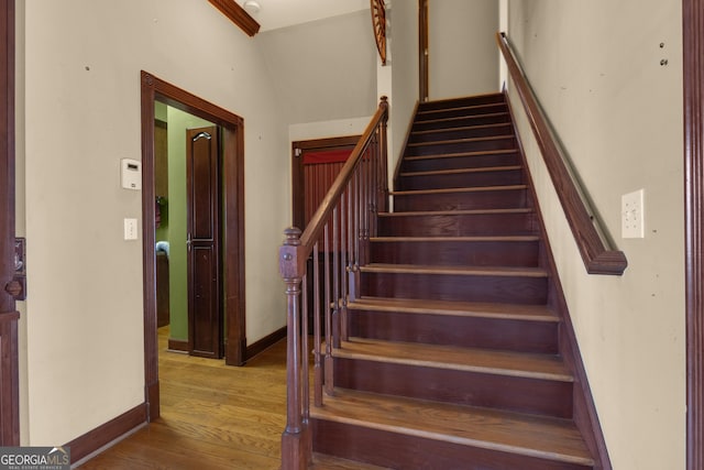 stairs with wood finished floors and baseboards