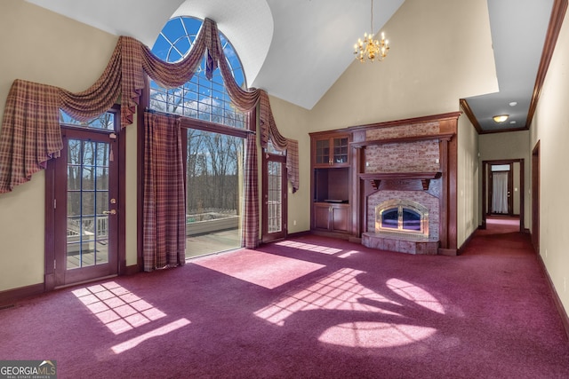 unfurnished living room featuring high vaulted ceiling, a fireplace, carpet flooring, baseboards, and a chandelier