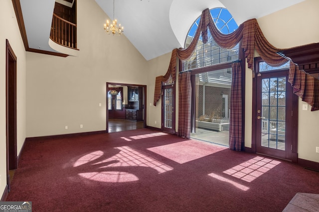 spare room with visible vents, high vaulted ceiling, carpet floors, baseboards, and a chandelier