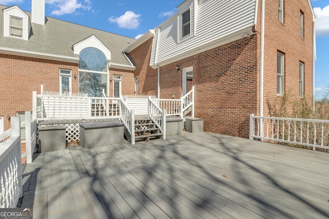 rear view of house with brick siding and a wooden deck