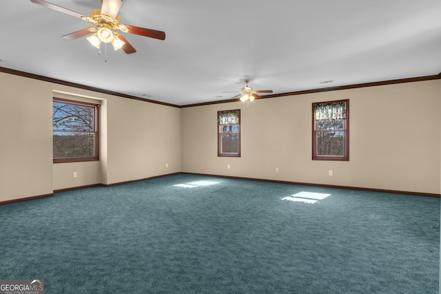 carpeted spare room with crown molding, baseboards, and a wealth of natural light