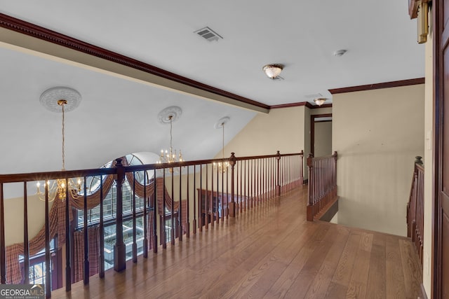 corridor with visible vents, vaulted ceiling with beams, hardwood / wood-style floors, an upstairs landing, and an inviting chandelier