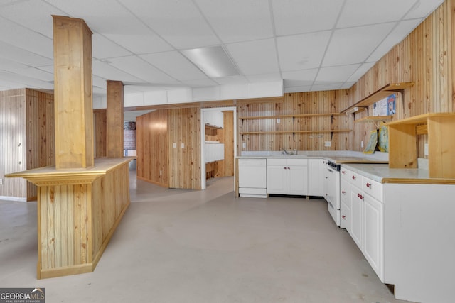 kitchen featuring wood walls, white cabinetry, concrete flooring, and open shelves