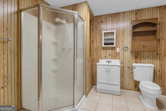 full bath with tile patterned floors, toilet, wood walls, and a shower stall