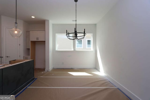 unfurnished dining area with recessed lighting, baseboards, and a chandelier